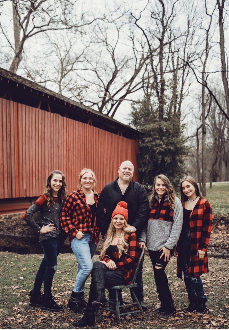 Scott Howell family portrait outdoors in fall with a red barn