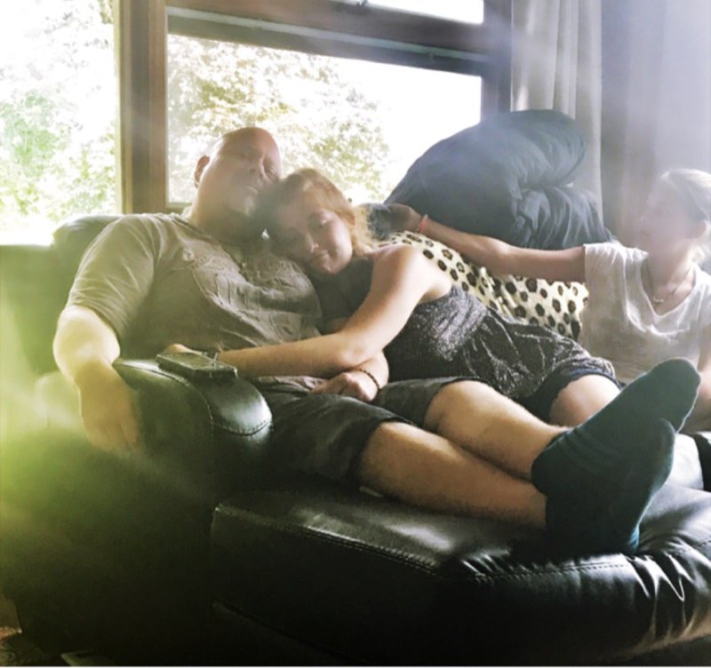 Scott Howell relaxing on the couch with his daughter