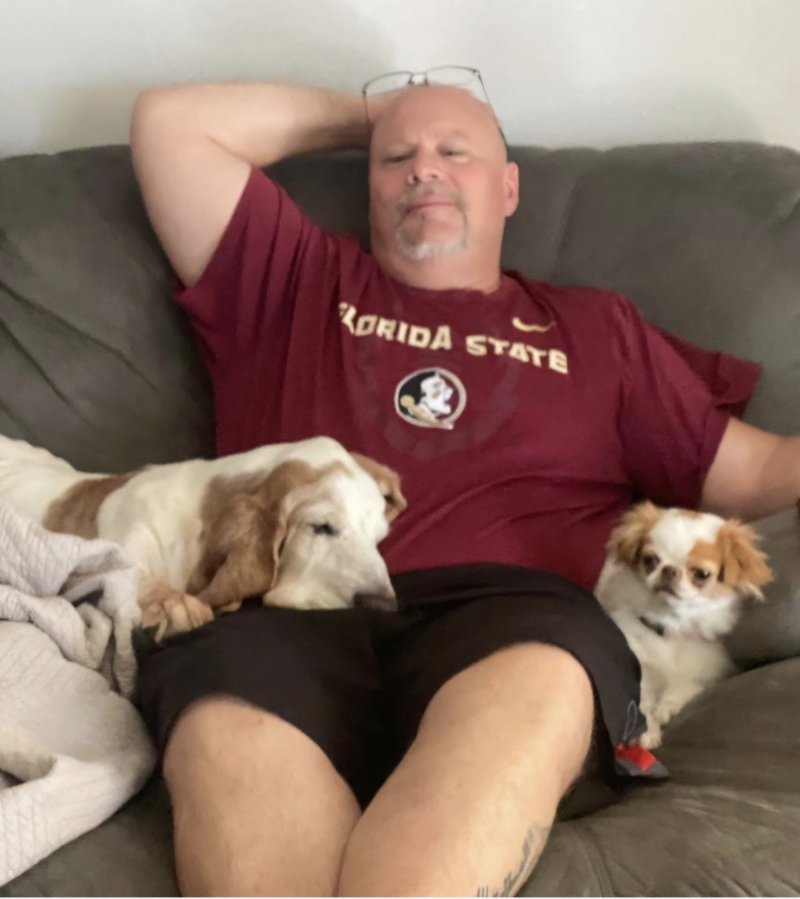 Scott Howell relaxing at home on the couch with his two dogs